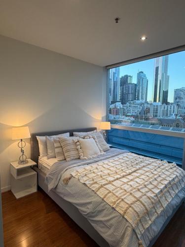a bed in a bedroom with a large window at Spacious landmark in the heart of CBD in Melbourne