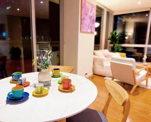 a white table with cups and saucers on it at Spacious landmark in the heart of CBD in Melbourne