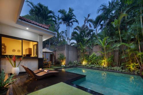 a villa with a swimming pool and a resort at Red Lotus Seminyak Villa in Seminyak
