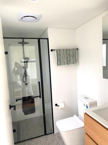 a bathroom with a toilet and a glass shower at Grampians View Eco Retreat in Halls Gap