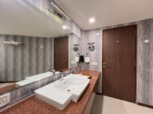 ein Badezimmer mit einem weißen Waschbecken und einer Badewanne in der Unterkunft Aayush Resort in Kālundri