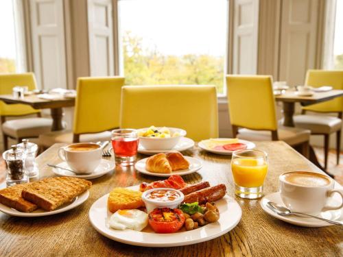 - une table avec des aliments pour le petit-déjeuner et du café dans l'établissement Mercure Chester Abbots Well Hotel, à Chester