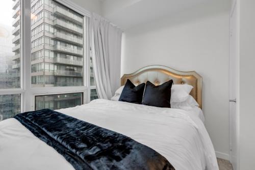 a bedroom with a bed with a large window at Luxe 3-Bedroom Lakeview Condo, Free parking ,Walk to CN Tower, Scotiabank Arena & Rogers Centre in Toronto