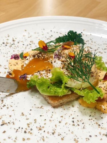 un panino su un piatto bianco con un coltello di Suntara Wellness Resort & Hotel a Chachoengsao