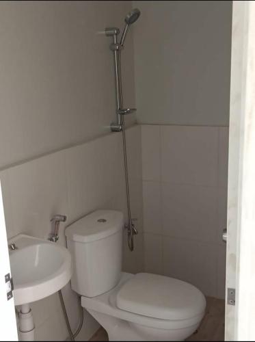 ein weißes Badezimmer mit Toilette und Waschbecken in der Unterkunft SMB place in Padada