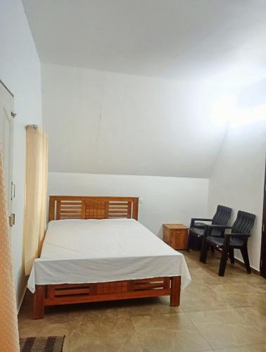 En eller flere senge i et værelse på Mullassery H Stay