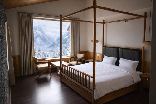 een slaapkamer met een bed en een groot raam bij Odbostays Manali in Haripūr