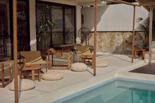 een zwembad met stoelen en een tafel en een tafel en een tafelblad bij Soul Temple Boutique Hotel ADULTS ONLY in Ahangama