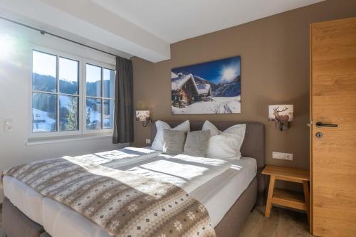 een slaapkamer met een groot bed en een raam bij Tauernlodge Sonnblick Top 2 in Mühlbach am Hochkönig