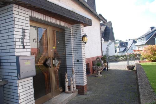 a door to a house with a patio at Pension Robin Hood in Willingen