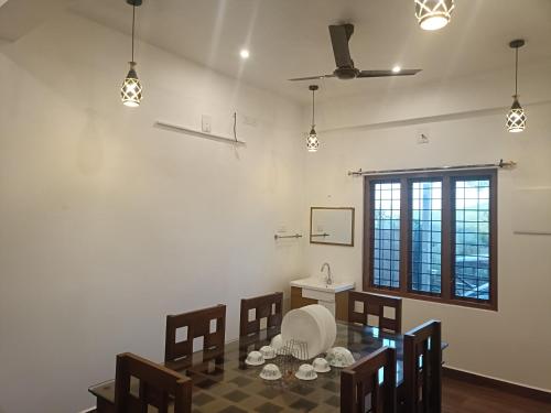 a dining room with a table and chairs and a window at Eva homes in Vagamon