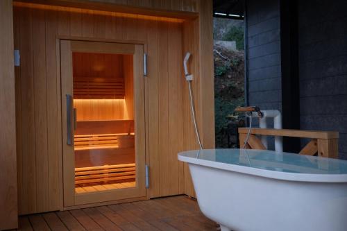 a bath tub sitting in front of a glass door at 海の宿mare in Hakui