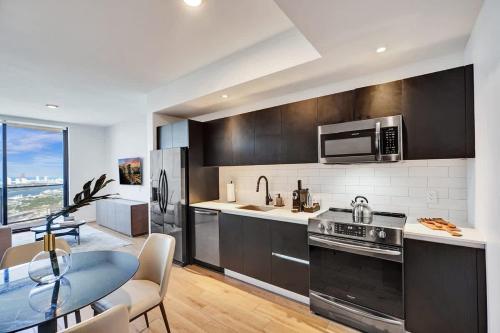 a kitchen with stainless steel appliances and a dining table at Miami Lux 1BR 37th Floor Bay City Views in Miami