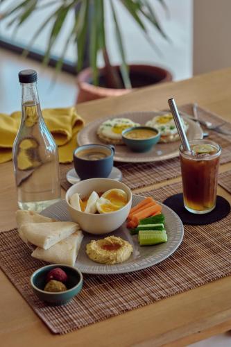 een tafel met een bord eten en een fles drank bij Soul Temple Boutique Hotel ADULTS ONLY in Ahangama