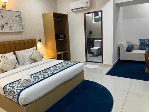 a bedroom with a large bed and a bathroom at The Dritan Brookefield ITPL Main Road in Bengaluru