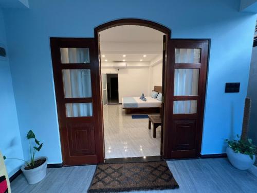 a door leading into a room with a bed and a bedroom at Blue Mind Surf Home in Weligama