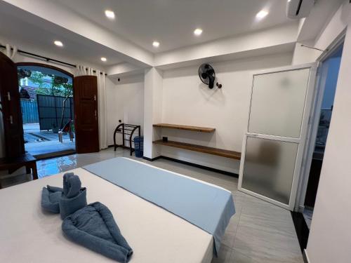 a room with a bed and a refrigerator at Blue Mind Surf Home in Weligama