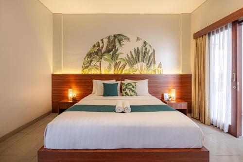 a bedroom with a large bed with two shoes on it at Cove Puspa Canggu in Canggu