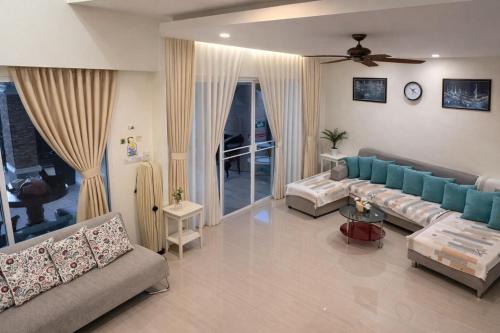 a living room with two couches and a table at Grand Chalong Family House in Chalong