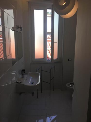 a bathroom with a sink and a toilet and a window at Casa Maria in Salerno