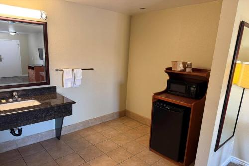 a bathroom with a sink and a microwave at Travelodge by Wyndham Hemet CA in Hemet