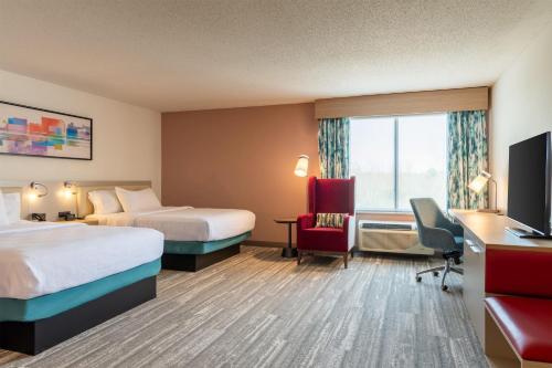 a hotel room with two beds and a desk at Hilton Garden Inn Portland Airport in Portland