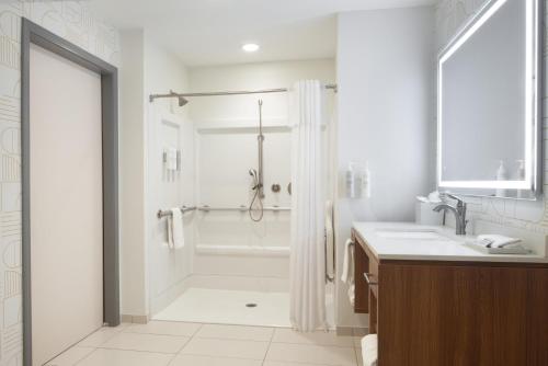 a white bathroom with a shower and a sink at Home2 Suites by Hilton Canton in North Canton