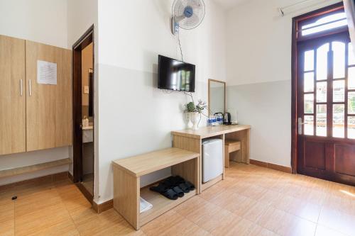 a room with a desk and a tv on a wall at Ngoc Nguyen Anh Hotel Da Lat in Da Lat
