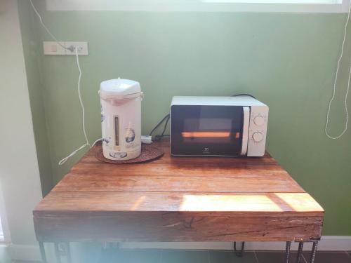 een tafel met een magnetron en een blender erop bij บ้านยาย Pool Villa in Loei