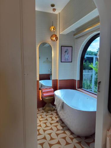 a large bathroom with two tubs and a toilet at Jc Pran บ้านพัก in Sam Roi Yot