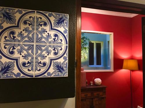 a bathroom with a mirror and a red wall at Apartamento Porto Baixa in Porto