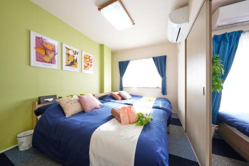 a bedroom with two beds with blue and white sheets at AO301 - Tokyo Stay Spacious Apartment Direct Train to Narita & Asakusa in Tokyo