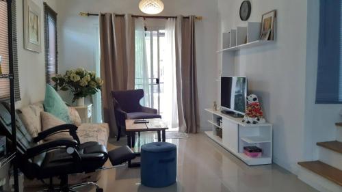 un salon avec un canapé et une télévision dans l'établissement Cosy Preuksa House 120, à Ban Bang Yai