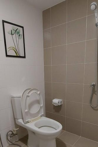 a bathroom with a toilet and a picture on the wall at Cosy Preuksa House 120 in Bang Yai