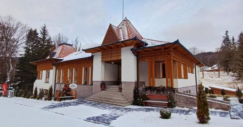 a small house with snow on the ground at Villa Bellini Borszék in Borsec