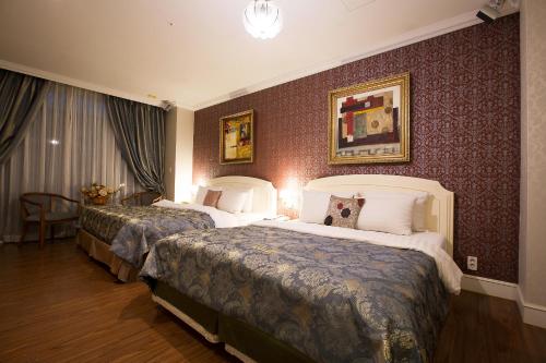 ein Hotelzimmer mit zwei Betten in einem Zimmer in der Unterkunft WIZ Hotel in Paju