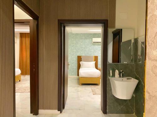 un bagno con lavandino e una camera da letto con un letto di رمادا نيت للشقق المخدومة a Tabuk