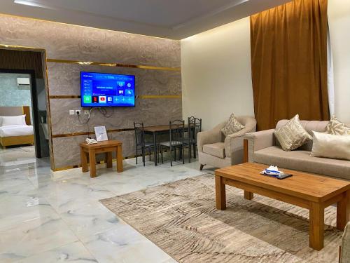 un soggiorno con un divano e un tavolo di رمادا نيت للشقق المخدومة a Tabuk
