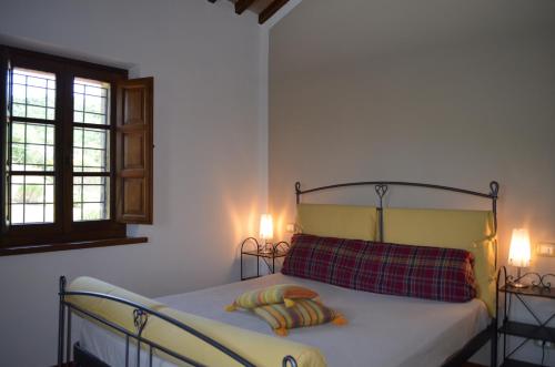 パニカーレにあるAgriturismo Poggio del Peroのベッドルーム1室(ランプ2つ、窓付)