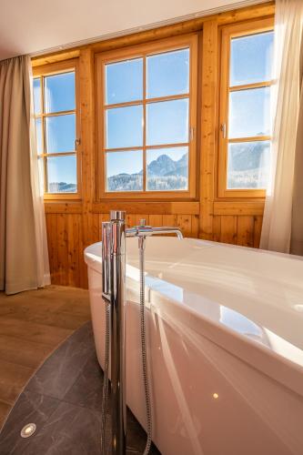 a bathroom with a bath tub and a window at Hotel Villa Stefania in San Candido
