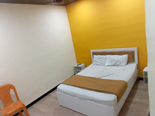 ein kleines Schlafzimmer mit einem Bett und einer gelben Wand in der Unterkunft sai villa lodging and boarding in Virār