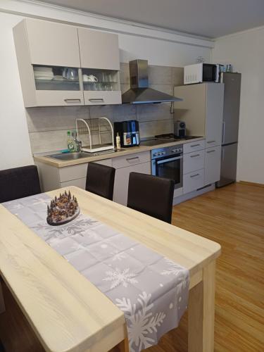 a kitchen with a wooden table with chairs and a dining room at Haus Piller in Bad Hofgastein