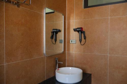 a bathroom with a sink and a mirror on the wall at Prova Home in Da Lat