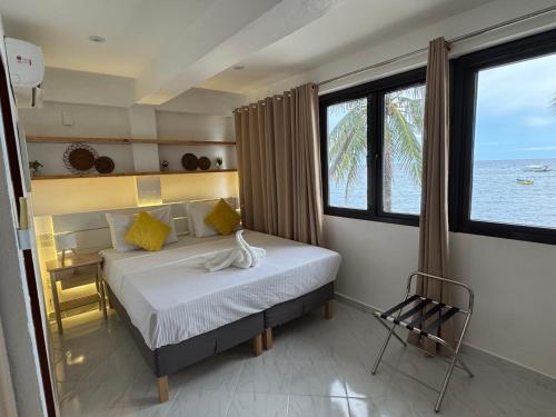 a bedroom with a bed with a view of the ocean at Alona Vida Beach Resort in Panglao