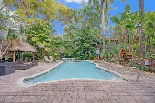 a swimming pool in the middle of a courtyard with trees at Tropical Oasis Studio w Pool in Fort Lauderdale