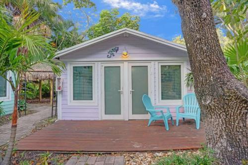 a cottage with two blue chairs on a wooden deck at Tropical Oasis 2BR w Pool in Fort Lauderdale