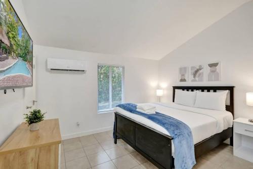 a white bedroom with a large bed and a window at Tropical Oasis Studio w Pool in Fort Lauderdale