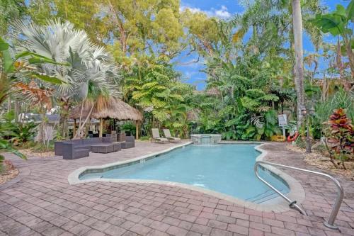 a swimming pool with a brick walkway next to a resort at Tropical Oasis Studio w Pool in Fort Lauderdale