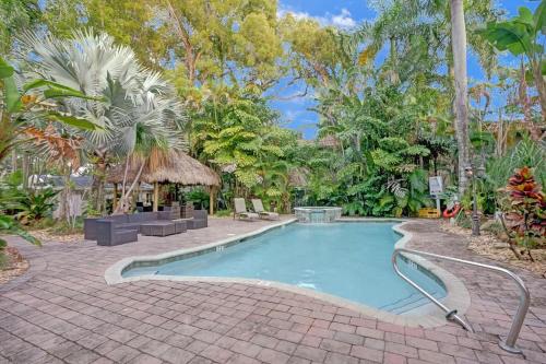 a swimming pool with a brick walkway around it at Tropical Oasis Studio w Pool in Fort Lauderdale