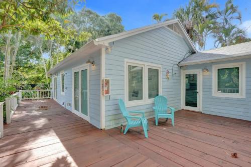 a house with two blue chairs on a wooden deck at Tropical Oasis 2BR House w Pool in Fort Lauderdale